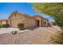 Inviting single-story home featuring desert landscaping, a two-car garage, and a red tile roof at 22284 W Mesquite Dr, Buckeye, AZ 85326
