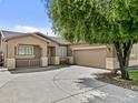 Single story home with well-manicured desert landscaping, spacious driveway, and a two car garage at 23077 S 214Th St, Queen Creek, AZ 85142