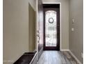Inviting foyer featuring a decorative front door, wood-look tile flooring, and neutral wall paint at 25449 N 102Nd Dr, Peoria, AZ 85383