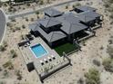 Stunning aerial view of a modern home with a private pool and desert landscaping at 3135 N Mountainside Loop, Buckeye, AZ 85396