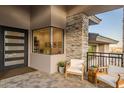 Inviting patio with comfortable seating and stone accents provides a welcoming entrance to the modern home at 3135 N Mountainside Loop, Buckeye, AZ 85396