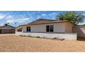 Desert-landscaped home with a white brick wall, with lush greenery on the side yard at 3826 W Davidson Ln, Phoenix, AZ 85051