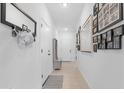 Bright hallway features neutral walls, tile floors, and decorative mirrors and pictures at 40365 W Bravo Dr, Maricopa, AZ 85138