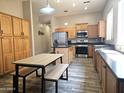 Eat-in kitchen showcasing wood-look floors, stainless appliances, and plentiful oak cabinetry at 4667 E County Down Dr, Chandler, AZ 85249