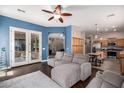 Open-concept living room featuring a large sectional couch, ceiling fan, and hardwood floors at 4667 E County Down Dr, Chandler, AZ 85249