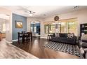 Inviting living room with wood floors, a cozy sofa, and large windows offering plenty of natural light and views at 4667 E County Down Dr, Chandler, AZ 85249