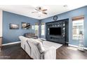 Entertainment room with wood floors, a cozy sofa, and a stylish entertainment center with a large flatscreen television at 4667 E County Down Dr, Chandler, AZ 85249