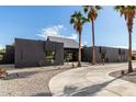 Stunning contemporary home featuring sleek lines, desert landscaping, and a spacious concrete driveway leading to the entrance at 5111 E Cortez Dr, Scottsdale, AZ 85254