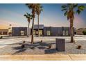 Contemporary home with a sleek gray exterior, desert landscaping, and palm tree accents at 5111 E Cortez Dr, Scottsdale, AZ 85254