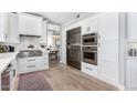 Modern kitchen featuring stainless steel appliances, white cabinets, and hardwood floors at 702 W Mountain Sky Ave, Phoenix, AZ 85045
