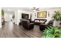 Spacious living room with a large TV, comfortable leather seating, and natural lighting at 7112 N 126Th Ln, Glendale, AZ 85307