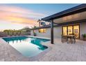 Inviting backyard featuring a refreshing pool, covered patio with dining area and lush greenery at 8117 E Lewis Ave, Scottsdale, AZ 85257