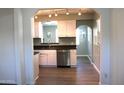 Modern kitchen with stainless steel appliances, white cabinetry, and dark countertops at 930 W Mackenzie Dr, Phoenix, AZ 85013