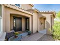 Welcoming covered front entry with a black front door, tile accents, and a charming sitting area at 13212 W Whisper Rock Trl, Peoria, AZ 85383