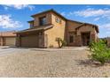 Two-story home featuring a 2-car garage, desert landscaping, and a neutral color scheme at 15429 W Statler Cir, Surprise, AZ 85374