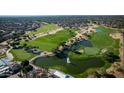 Aerial view showcases lush golf course with mature trees, a tranquil pond and well maintained landscaping in this community at 15635 W Hackamore Dr, Surprise, AZ 85387