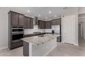 Gourmet kitchen boasts stainless steel appliances, granite countertops, a center island, and ample cabinet space at 15899 S 183Rd Dr, Goodyear, AZ 85338