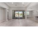 Bright, open living room with tile floors and expansive sliding glass doors leading to the backyard patio at 15899 S 183Rd Dr, Goodyear, AZ 85338