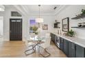 Elegant dining room features a glass table, stylish white chairs, modern lighting, and a built-in bar area at 16389 N 108Th Pl, Scottsdale, AZ 85255