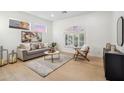 Bright living room featuring modern furniture, a large arched window, and neutral decor with hardwood floors at 16389 N 108Th Pl, Scottsdale, AZ 85255