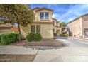 Two-story home with a stucco exterior, landscaping, and a tree in the front yard on a sunny day at 17374 W Adams St, Goodyear, AZ 85338