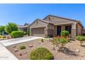 Landscaped front yard with vibrant plants leading up to an attractive single-story home with stone accents at 18008 W Tina Ln, Surprise, AZ 85387
