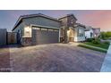 Charming single-story home featuring stone accents, a well-manicured lawn, and a spacious gray garage door at 18358 W Christy Dr, Surprise, AZ 85388