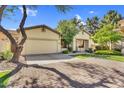 A beautifully maintained home featuring an inviting facade, manicured lawn, and a spacious driveway leading to the garage at 2000 W Periwinkle Way, Chandler, AZ 85248