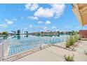 Expansive backyard view featuring a serene lake, a metal fence, and mature landscaping at 2094 N Sweetwater Dr, Casa Grande, AZ 85122