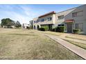 Well-maintained two-story condo building with red tile roof, arched entryway, and mature landscaping at 225 N Standage -- # 89, Mesa, AZ 85201