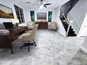 Large home office featuring a wooden desk, contemporary decor, comfortable beige chairs, and staircase access at 3330 W Gran Paradiso Dr, Phoenix, AZ 85086