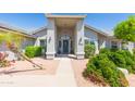 Inviting covered entryway with desert landscaping and a well manicured lawn at 3544 E Fox St, Mesa, AZ 85213