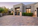 Home features a beautiful desert landscape, brick driveway, and a modern entryway with decorative plants at 39847 N 105Th Pl, Scottsdale, AZ 85262