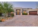 Stunning home featuring a desert landscape, brick driveway, and a custom front door with decorative plantings at 39847 N 105Th Pl, Scottsdale, AZ 85262