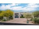 Attractive home with desert landscaping, circular driveway, and modern front door at 39847 N 105Th Pl, Scottsdale, AZ 85262