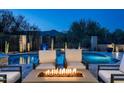 Inviting pool area featuring comfortable seating, a fire pit, and stunning mountain views in the background at 39847 N 105Th Pl, Scottsdale, AZ 85262