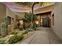 Home entryway featuring a private courtyard with mature cacti, desert landscaping, and statement front door at 41590 N 108Th St, Scottsdale, AZ 85262