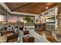 Spacious living room featuring a stone fireplace, wooden ceilings, and floor-to-ceiling windows at 41590 N 108Th St, Scottsdale, AZ 85262