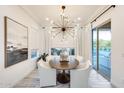 Bright dining room featuring modern chandelier, with seating for six, and large glass sliding doors at 5901 E Sierra Morena St, Mesa, AZ 85215