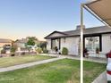 Attractive single-story home boasts a lush lawn, garden, decorative planters, and a covered carport for convenient parking at 7943 W Mariposa Dr, Phoenix, AZ 85033