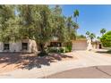 Charming single-story home featuring a well-manicured front yard, mature trees, and an attached two-car garage at 8306 E Via De Dorado --, Scottsdale, AZ 85258