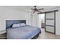 Comfortable main bedroom with ceiling fan and barn door to ensuite bathroom at 905 E Bluefield Ave, Phoenix, AZ 85022