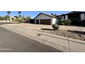 Traditional house with a two-car garage, a basketball hoop, and desert landscaping at 10205 E Corrine Dr, Scottsdale, AZ 85260