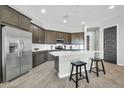 Modern kitchen featuring stainless steel appliances, an island with bar seating, and stylish wood-look flooring at 11575 N 190Th Ln, Surprise, AZ 85388