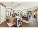 An open kitchen with grey cabinets, granite countertops, stainless steel appliances and a view of the dining area at 13088 N 91St Dr, Peoria, AZ 85381