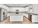 Bright kitchen featuring white cabinets, granite countertops, stainless steel appliances, and an island at 13294 W Eagle Feather Rd, Peoria, AZ 85383