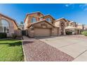 Two-story home featuring a three-car garage, neutral color scheme, grass, desert landscaping, and a concrete driveway at 13750 W Roanoke Ave, Goodyear, AZ 85395