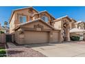 Two-story home featuring a three-car garage, neutral color scheme, desert landscaping, and a concrete driveway at 13750 W Roanoke Ave, Goodyear, AZ 85395