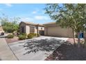 Charming home featuring a two car garage, desert landscaping, and well-maintained front yard at 18023 W Statler St, Surprise, AZ 85388