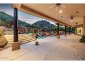 Lush backyard with a covered patio, outdoor kitchen, waterfall features, and mountain views at 24644 N 114Th St, Scottsdale, AZ 85255